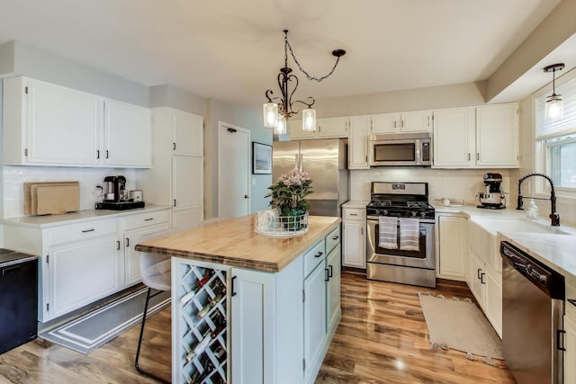 405 W Ivy Ln Unit 4A, Arlington Heights, IL 60004 - kitchen featuring stainless steel appliances, a sink, white cabinetry, and decorative backsplash