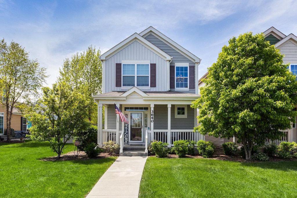 3640 Daisy Ln, Elgin, IL 60124 - view of front facade with board and batten siding, a porch, and a front lawn