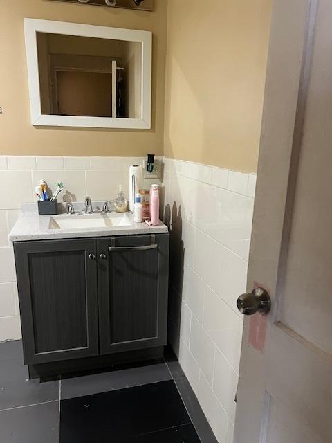 1428 S St Louis Ave, Chicago, IL 60623 - bathroom with tile walls, a wainscoted wall, vanity, and tile patterned floors