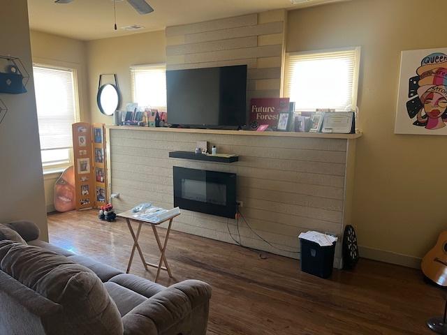 1428 S St Louis Ave, Chicago, IL 60623 - living room featuring wood finished floors, a glass covered fireplace, a ceiling fan, and baseboards