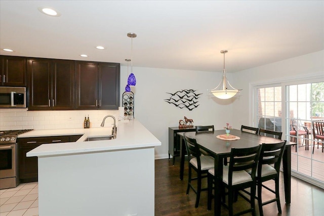 1608 W Ethans Glen Dr, Palatine, IL 60067 - kitchen featuring appliances with stainless steel finishes, a sink, dark brown cabinetry, backsplash, and light countertops