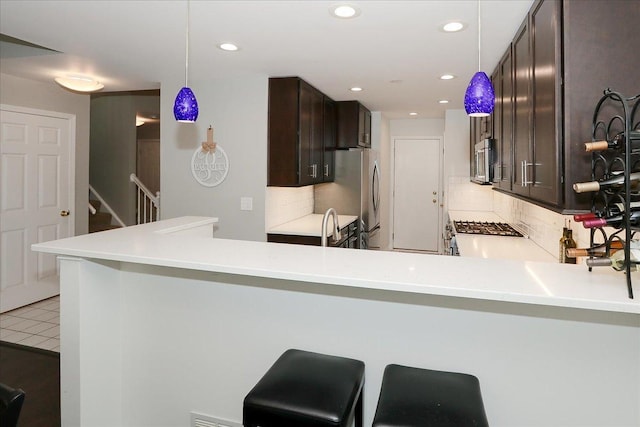 1608 W Ethans Glen Dr, Palatine, IL 60067 - kitchen with stainless steel appliances, dark brown cabinets, backsplash, light countertops, and recessed lighting