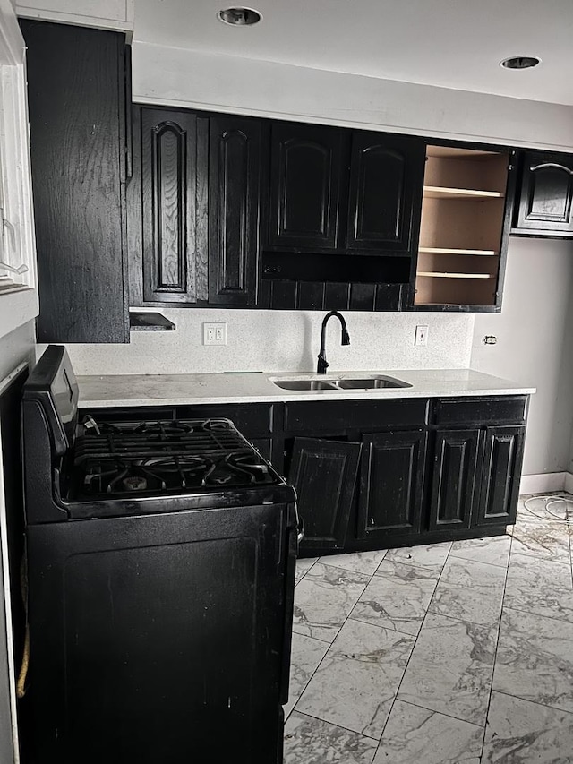 17814 Burnham Ave, Lansing, IL 60438 - kitchen featuring black gas stove, dark cabinetry, a sink, and light marble finish floors