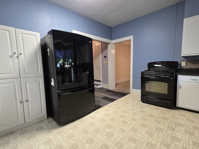 101 4th St, Fisher, IL 61843 - kitchen with black appliances, white cabinetry, and baseboards