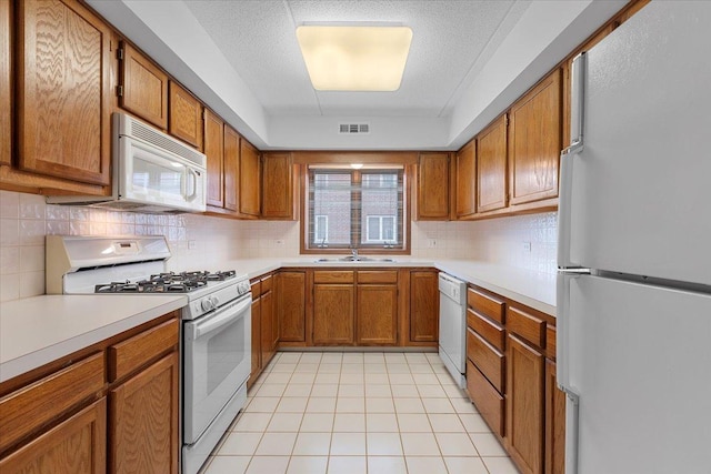 5255 N Riversedge Ter Unit 206, Chicago, IL 60630 - kitchen featuring white appliances, brown cabinets, a sink, light tile patterned floors, and tasteful backsplash