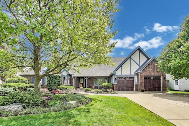 2041 Chatham Dr, Wheaton, IL 60189 - tudor house with a garage, concrete driveway, brick siding, and a front lawn