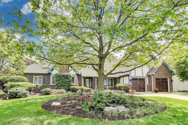 2041 Chatham Dr, Wheaton, IL 60189 - tudor house with concrete driveway, brick siding, a garage, and a front lawn