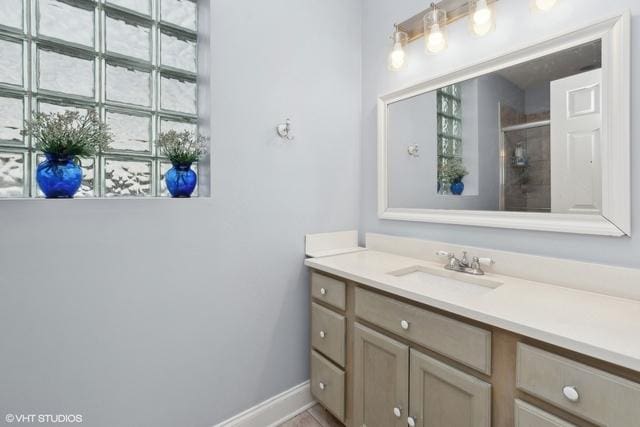 3934 W Argyle St Unit 3, Chicago, IL 60625 - bathroom with vanity, a tile shower, baseboards, and plenty of natural light