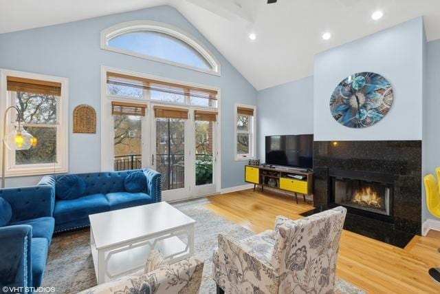 3934 W Argyle St Unit 3, Chicago, IL 60625 - living room with lofted ceiling, wood finished floors, healthy amount of natural light, a tiled fireplace, and recessed lighting