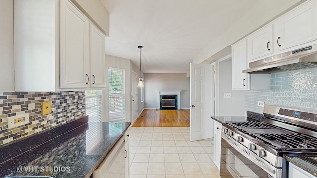 2135 Schumacher Dr, Naperville, IL 60540 - kitchen featuring gas range, under cabinet range hood, a glass covered fireplace, light tile patterned flooring, and white cabinetry