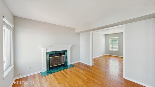 2135 Schumacher Dr, Naperville, IL 60540 - unfurnished living room featuring light wood finished floors, a premium fireplace, and baseboards