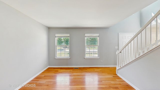 2135 Schumacher Dr, Naperville, IL 60540 - empty room featuring stairway, light wood-style floors, and baseboards