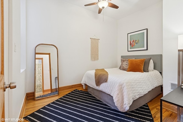 bedroom featuring wood finished floors, baseboards, and a ceiling fan