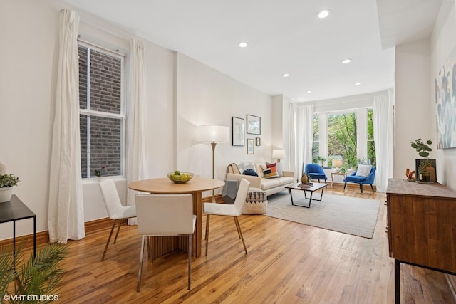 dining area with light wood finished floors and recessed lighting