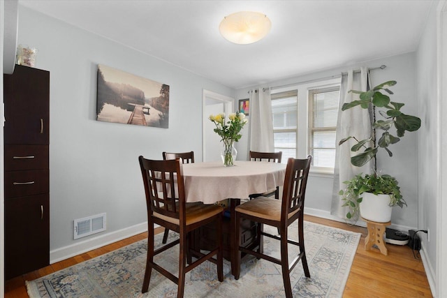 dining room featuring light wood-type flooring and baseboards