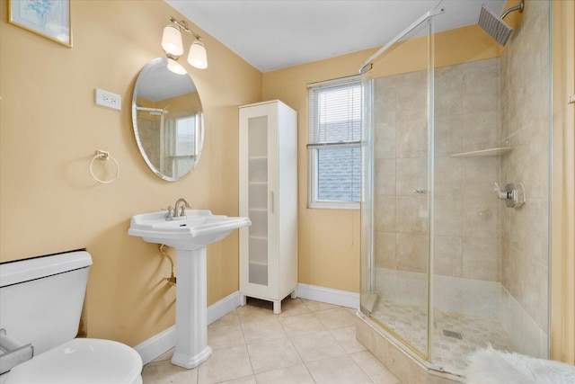 bathroom featuring a stall shower, baseboards, toilet, and tile patterned floors