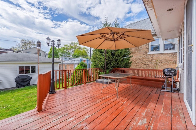 wooden deck with outdoor dining area, grilling area, and a yard