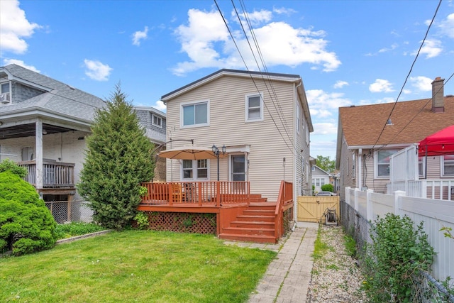 back of property with a gate and a wooden deck