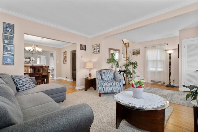 living area with wood finished floors, plenty of natural light, a chandelier, baseboards, and crown molding