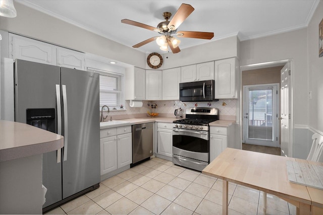 kitchen featuring appliances with stainless steel finishes, a sink, light tile patterned floors, light countertops, and tasteful backsplash