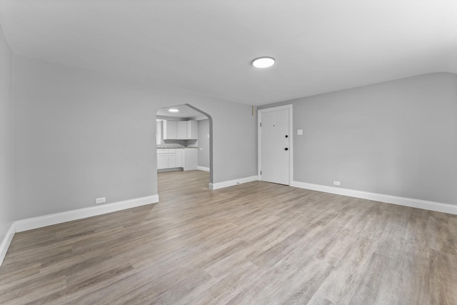 7133 W 16th St, Berwyn, IL 60402 - unfurnished living room featuring arched walkways, baseboards, light wood-style flooring, and recessed lighting