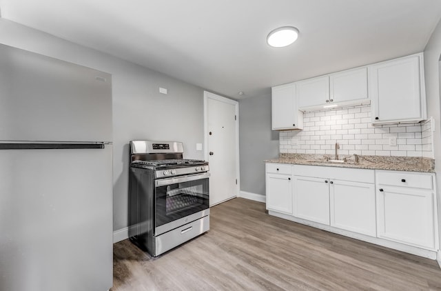 7133 W 16th St, Berwyn, IL 60402 - kitchen featuring stainless steel gas range, freestanding refrigerator, light wood-style floors, a sink, and baseboards