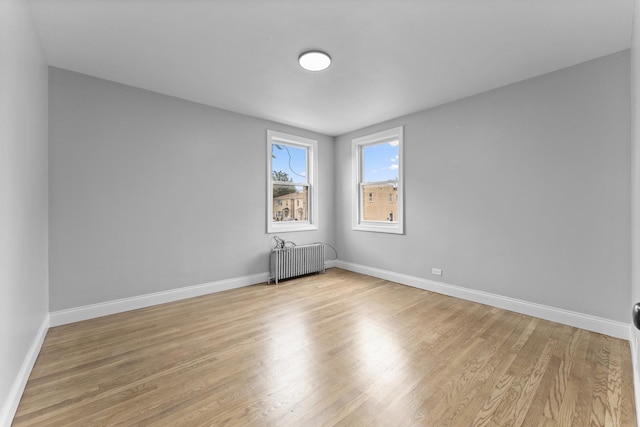7133 W 16th St, Berwyn, IL 60402 - empty room with radiator heating unit, light wood finished floors, and baseboards