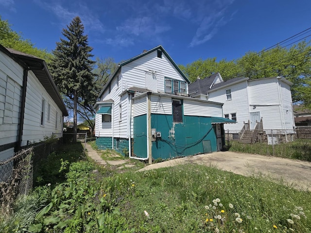 rear view of house featuring fence