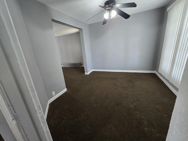 spare room featuring carpet floors, a ceiling fan, and baseboards