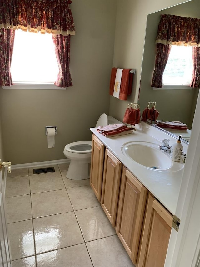bathroom with tile patterned flooring, toilet, vanity, and baseboards