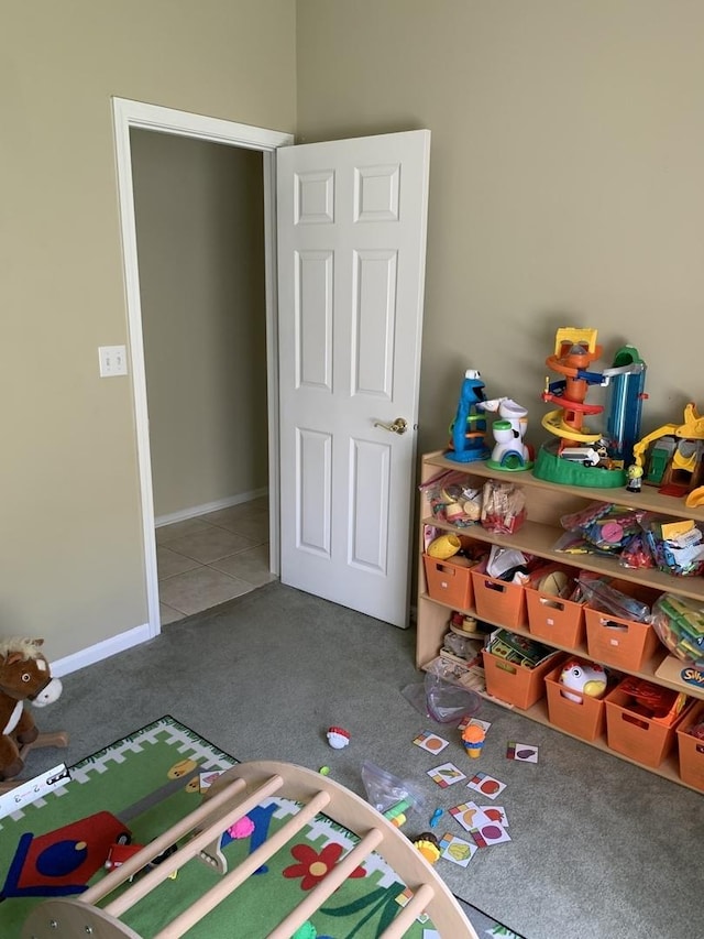 recreation room featuring carpet floors, baseboards, and tile patterned flooring