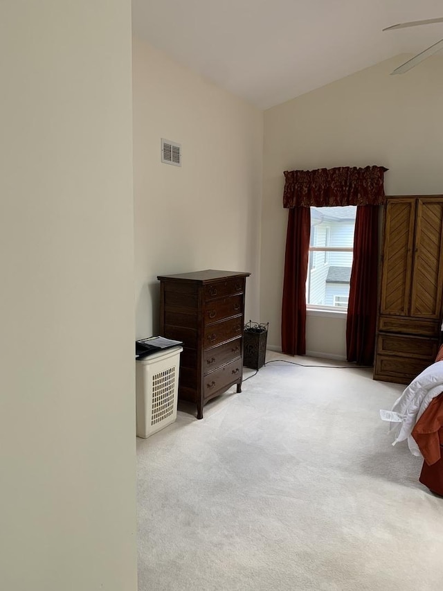 bedroom with light colored carpet and vaulted ceiling