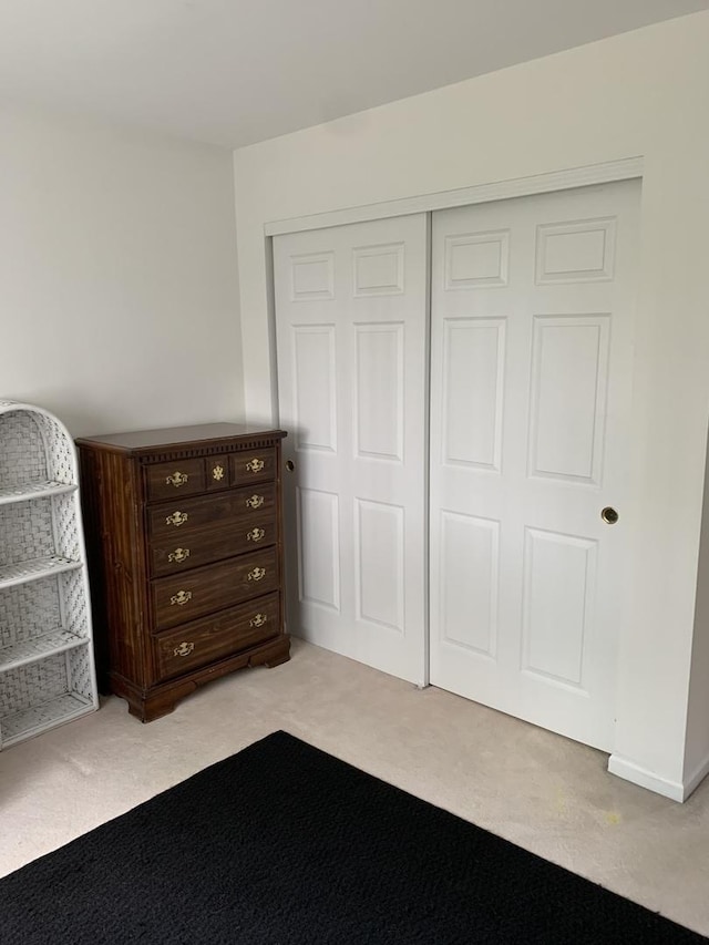 bedroom featuring light carpet and a closet