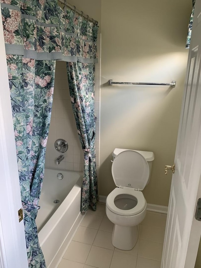 bathroom featuring tile patterned floors, shower / tub combo with curtain, toilet, and baseboards