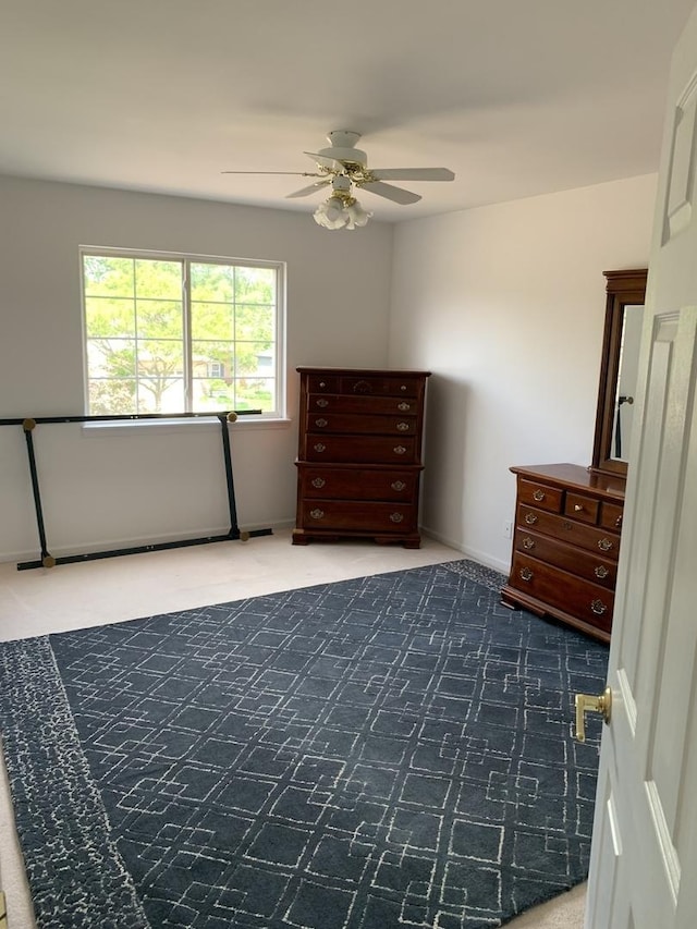 carpeted bedroom featuring ceiling fan and baseboards