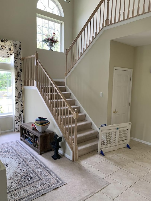 stairs featuring healthy amount of natural light, baseboards, and tile patterned flooring