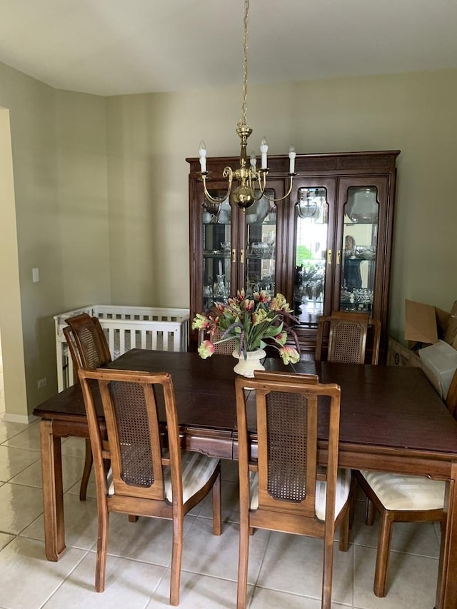 dining area with a chandelier and light tile patterned flooring