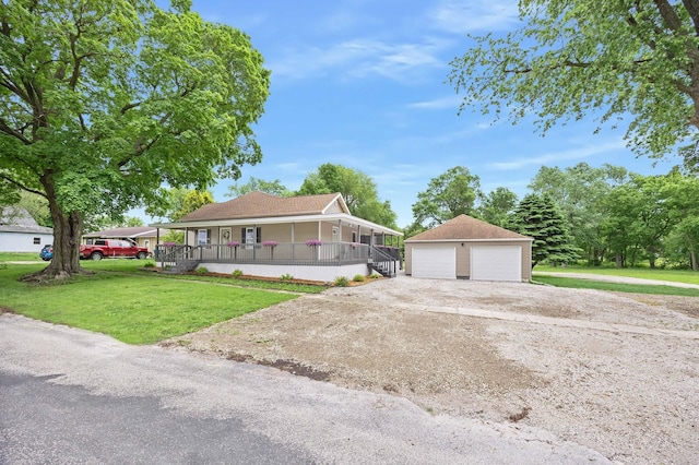 104 S Taylor St, Towanda, IL 61776 - country-style home featuring a porch, a detached garage, a front yard, and an outdoor structure