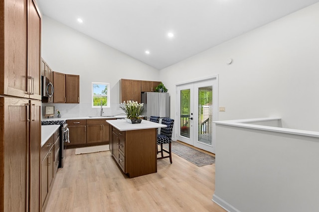 104 S Taylor St, Towanda, IL 61776 - kitchen featuring stainless steel appliances, a breakfast bar area, a center island, high vaulted ceiling, and light wood-style flooring