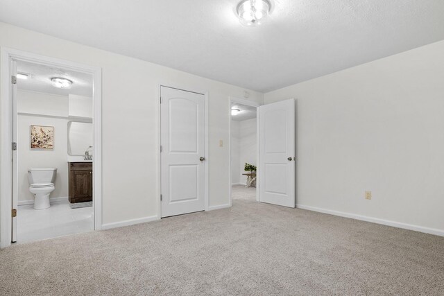 104 S Taylor St, Towanda, IL 61776 - unfurnished bedroom with carpet flooring, ensuite bathroom, and baseboards