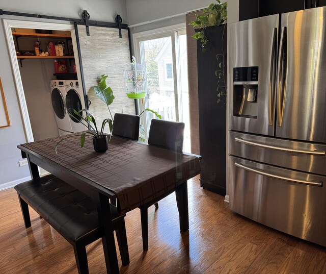 2406 Daybreak Ct, Elgin, IL 60123 - dining space with washer and dryer, wood finished floors, baseboards, and a barn door
