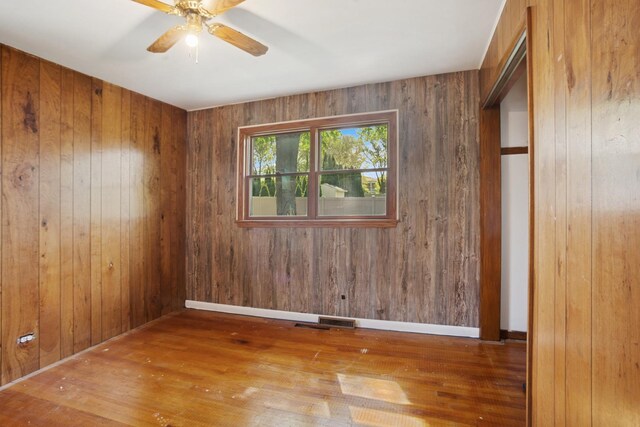 133 Maple Ct, Bloomingdale, IL 60108 - unfurnished room featuring wood finished floors, ceiling fan, wooden walls, and baseboards