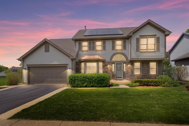 930 Ripple Brook Ln, Elgin, IL 60120 - view of front of house featuring asphalt driveway, a shingled roof, a front yard, roof mounted solar panels, and an attached garage