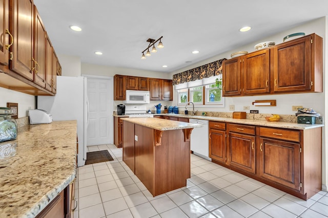 930 Ripple Brook Ln, Elgin, IL 60120 - kitchen with white appliances, a kitchen breakfast bar, light stone counters, a kitchen island, and a sink