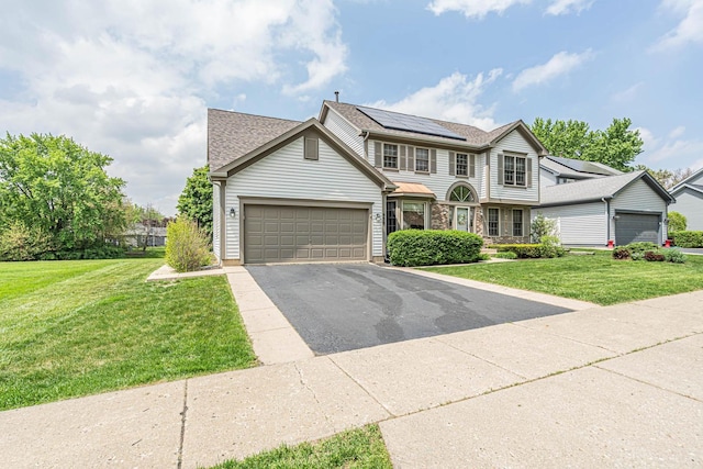 930 Ripple Brook Ln, Elgin, IL 60120 - traditional-style house with roof mounted solar panels, a garage, driveway, a front yard, and a shingled roof
