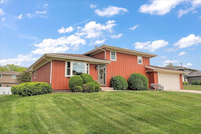 tri-level home with a front yard, an attached garage, and concrete driveway