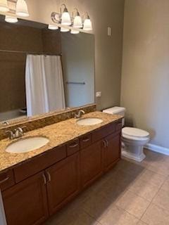 140 S River St Unit 208, Aurora, IL 60506 - full bathroom with tile patterned floors, toilet, double vanity, baseboards, and a chandelier