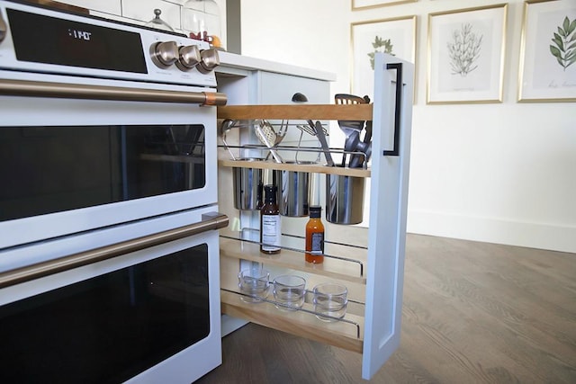 kitchen view of double oven and wood finished floors