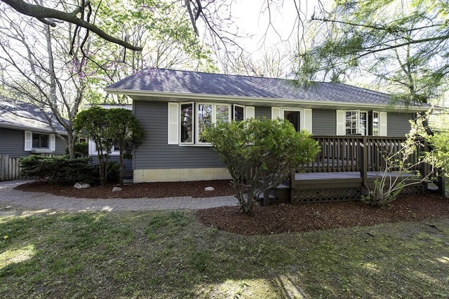 ranch-style home with a deck and a shingled roof