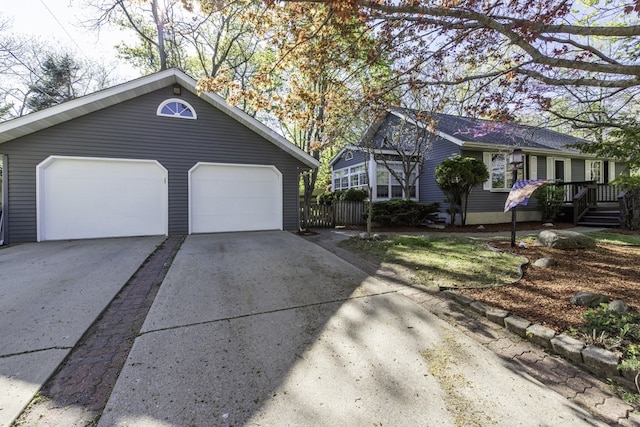 ranch-style house with driveway and fence